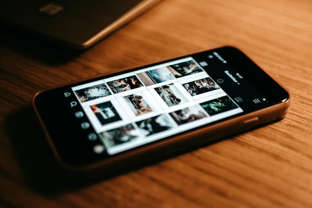 Téléphone sur un bureau, en train de choisir les photos à publier sur les réseaux sociaux